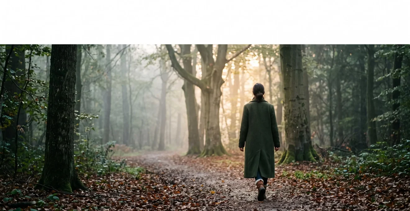 Silhouette d'une personne marchant seule sur un chemin brumeux en forêt à l'aube, symbolisant la transformation progressive des habitudes de vie pour renforcer l'immunité